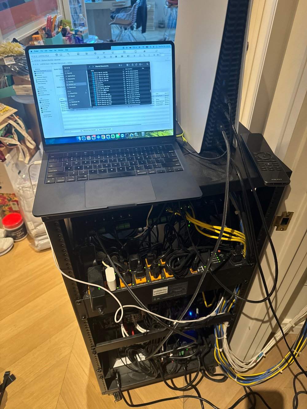 Office workspace with desktop computer tower system mounted on a black equipment stand, displaying open